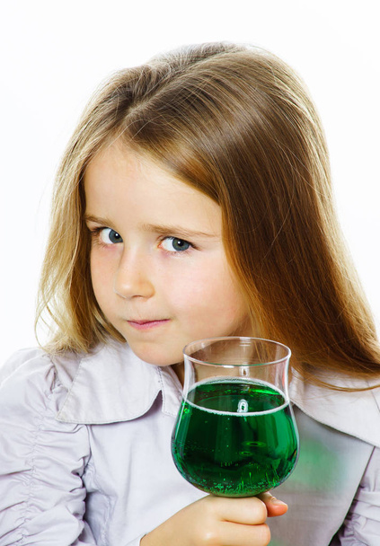 Little girl with glass of vivid green liquid, maybe poison - Fotoğraf, Görsel