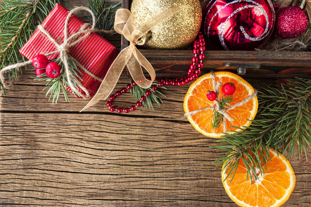 Christmas toy and tangerine on a wooden background - Photo, Image