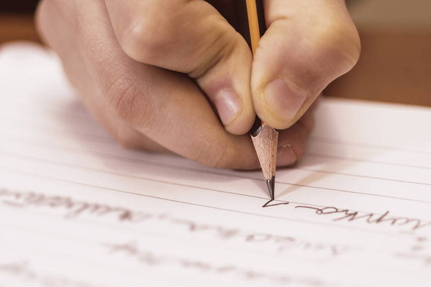 School Boy Writing Close Up. Lápiz en la mano de los niños
. - Foto, Imagen