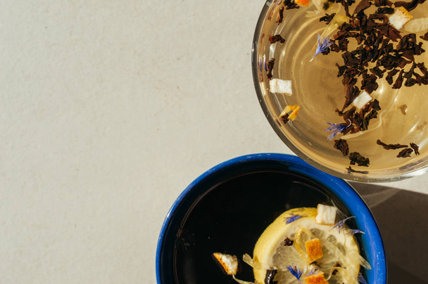 Thé noir aux fleurs bleues, écorce d'orange et pétales dans un transpa
 - Photo, image
