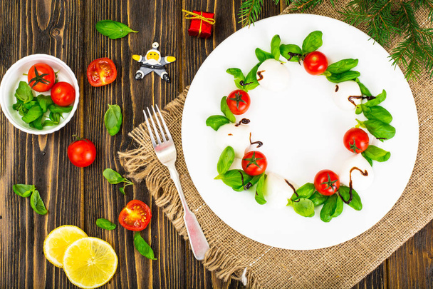 Ghirlanda di Natale insalata caprese antipasto festivo su un piatto bianco
 - Foto, immagini