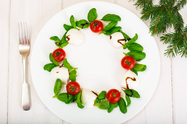 Karácsonyi koszorú caprese salátával ünnepi előétel a fehér plat - Fotó, kép