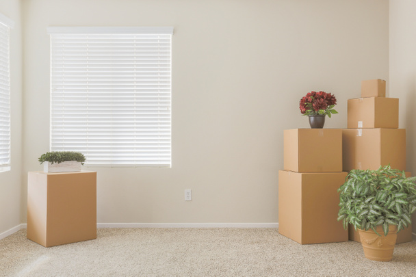 Variété de boîtes de déménagement emballées dans une pièce vide
 - Photo, image