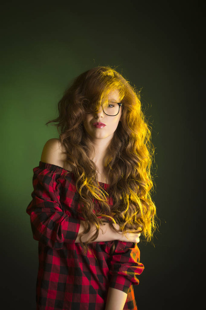 Glamorous young model with long wavy hair wearing glasses - Fotó, kép