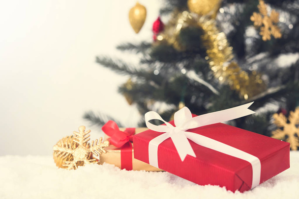 Cajas de regalo y adornos navideños en la nieve
 - Foto, Imagen
