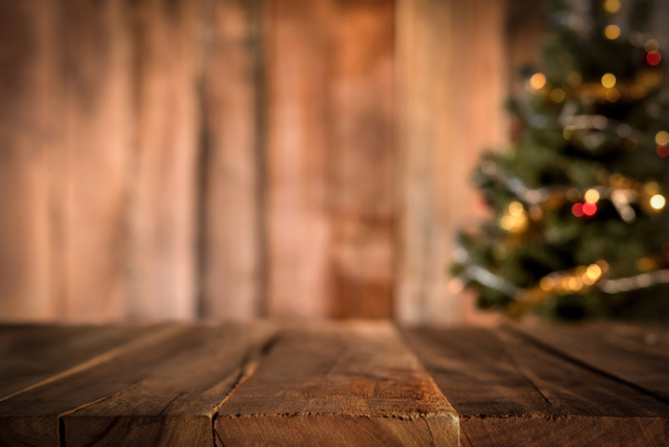 Παλιά ξύλινη επιτραπέζια με θολούρα χριστουγεννιάτικο δέντρο στο παρασκήνιο - Φωτογραφία, εικόνα