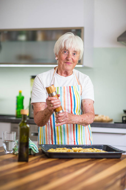 Senior woman cooking in the kitchen - 写真・画像