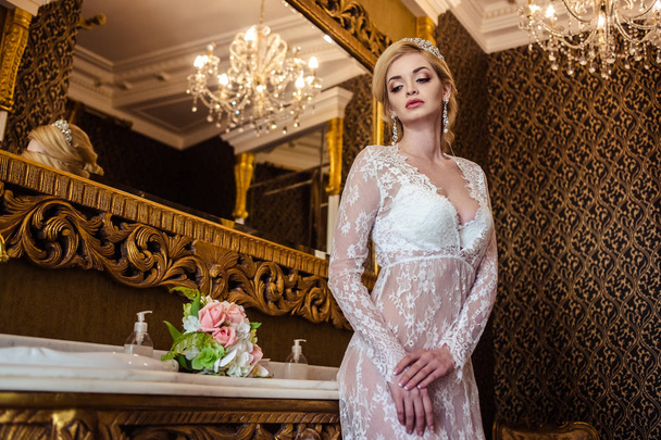 beautiful blonde young woman in white lingerie in a bathroom interior. bride's morning - Fotografie, Obrázek