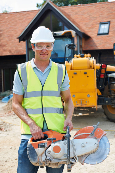 Construction Worker On Site Holding Circular Saw - Foto, Imagem