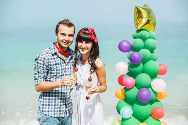 ζευγάρι στέκεται κοντά σε μπαλόνι δέντρο στην παραλία - Φωτογραφία, εικόνα