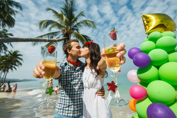 пара, стоящая возле дерева воздушного шара на пляже
 - Фото, изображение