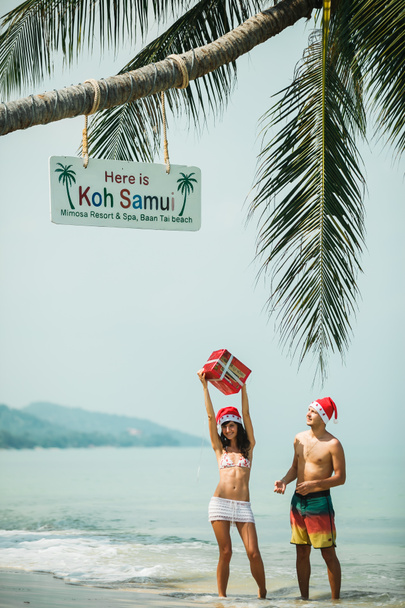 pareja de pie con caja de regalo en la playa
 - Foto, imagen