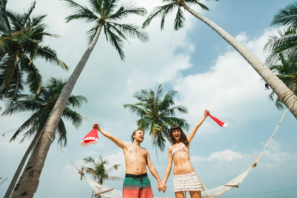 casal de pé perto de rede na praia
 - Foto, Imagem