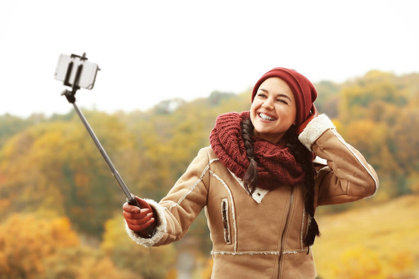 Beautiful young woman taking photos outdoors - Photo, Image