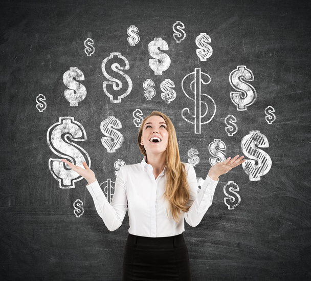 Femme d'affaires blonde gaie près du tableau noir avec des signes de dollar
 - Photo, image