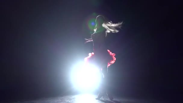 Дівчина танцює ча-ча на темному тлі зі світловим ілюмінатором. Повільний рух
 - Кадри, відео