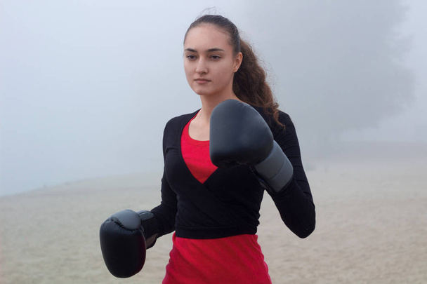 Jovem mulher esportiva faz exercícios de boxe durante o treino de fitness
  - Foto, Imagem