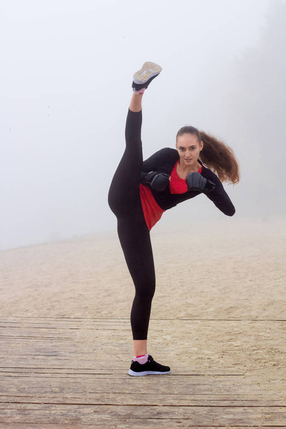 Jonge sportieve vrouw doet boksen oefeningen tijdens fitnesstraining - Foto, afbeelding