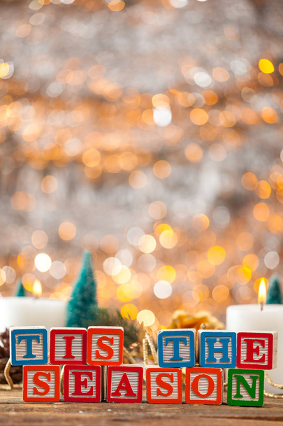 Tis a estação escrita com blocos de brinquedo no cartão de Natal vertical
 - Foto, Imagem