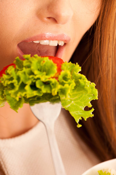egészséges táplálkozás - nő eszik egy tál görög salátával, elszigetelt, felett - Fotó, kép