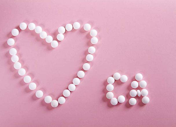 pills forming shape to heart and CA - Valokuva, kuva