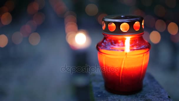 Kerkhof bij nacht met kleurrijke kaarsen voor Allerheiligen. Allerheiligen is een hoogfeest gevierd op 1 November door de katholieke kerk. Statische opname. - Video