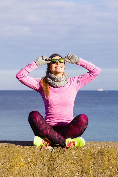 Woman resting after doing sports outdoors on cold day - Foto, Imagen