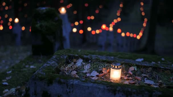 Cmentarz w nocy z kolorowe świece na dzień wszystkich świętych. Dzień wszystkich świętych jest uroczystość obchodzony 1 listopada przez Kościół katolicki. Statycznego ujęcia. - Materiał filmowy, wideo