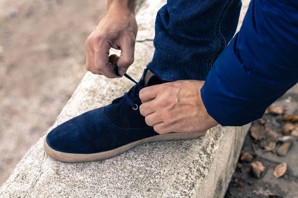 jongeman koppelverkoop schoenveters  - Foto, afbeelding