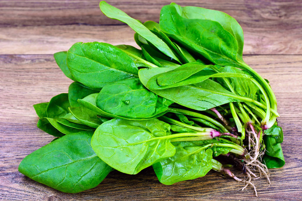 Juicy Fresh Spinach deja sobre fondo leñoso
 - Foto, Imagen