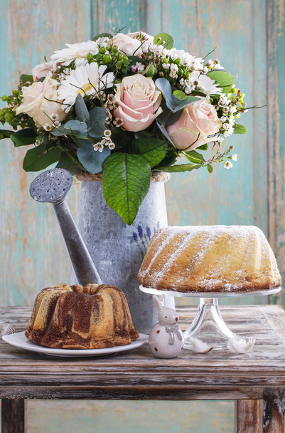 Bouquet of pink roses and white gerbera flowers, easter cakes. - 写真・画像