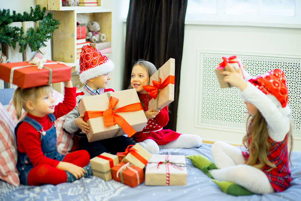 Group of kids in red hat with Christmas gifts - 写真・画像