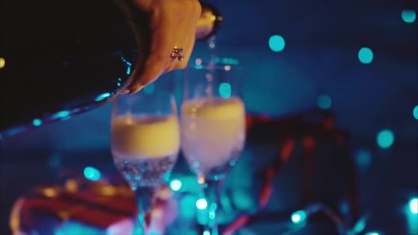 Şampanya şişesinden dökme, iki köpüklü şarap bokeh yanıp sönen ile flüt - Video, Çekim