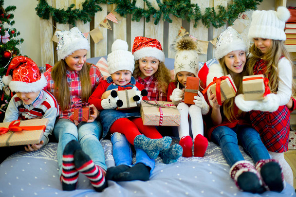Group of kids in red hat with Christmas gifts - Fotoğraf, Görsel