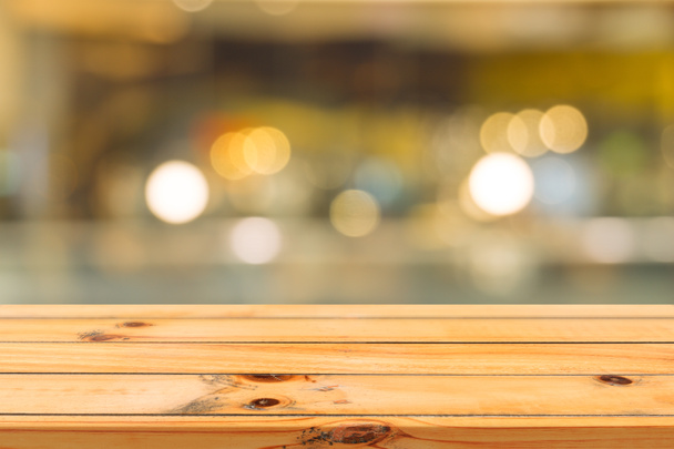Houten bord leeg tafelblad met wazige achtergrond. Perspectief bruin houten tafel over wazig in coffeeshop achtergrond - kan worden gebruikt mock up voor montage producten display of design sleutel visuele lay-out. - Foto, afbeelding