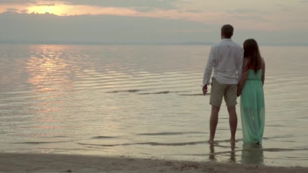 Boldog fiatal pár pillantást a tengeri naplemente koncepció, a szeretet és a kapcsolatok - Felvétel, videó