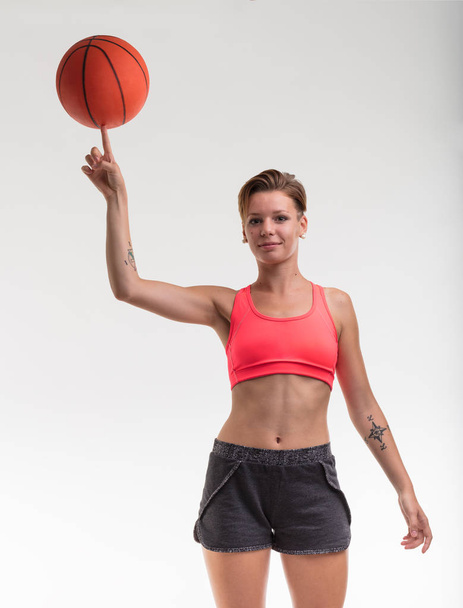 Frau balanciert Basketball auf dem Finger - Foto, Bild