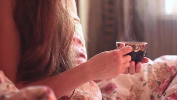 Dziewczyna picia kawy w łóżku - Materiał filmowy, wideo