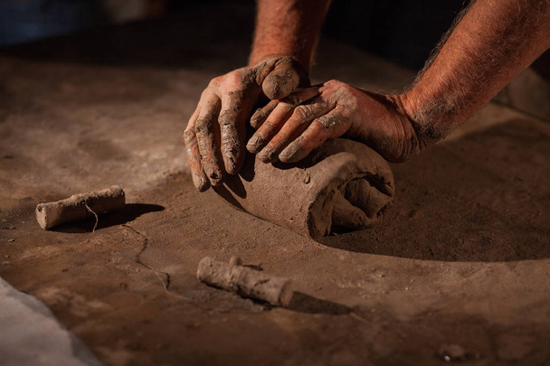 Hands of the potter knead clay. - 写真・画像