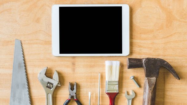 Set of different work tools with tablet on wooden table background. - Foto, Bild