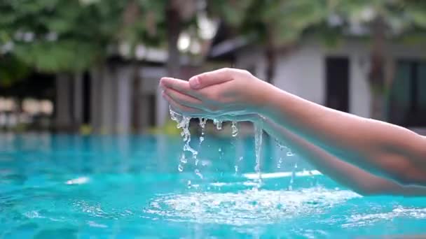 in the palm of the hand men recruited water and poured into the hotel pool - Filmmaterial, Video