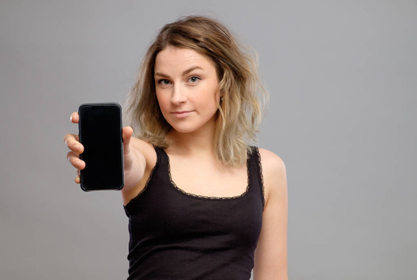 Woman showing blank smartphone screen - Valokuva, kuva