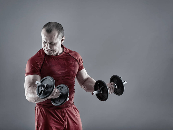 Man doing biceps curl with dumbbells - 写真・画像