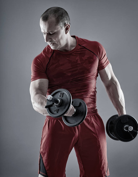 Man doing biceps curl with dumbbells - Foto, immagini