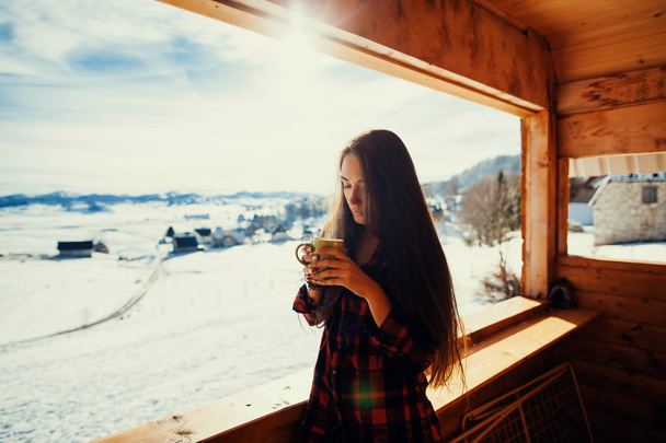 girl drinks tea on winter terrace - Photo, Image