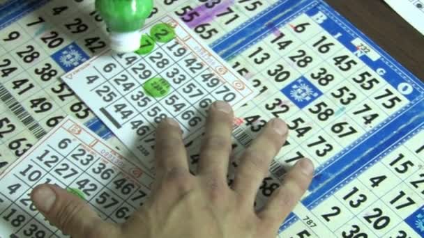 ένας άνθρωπος σήματα-off κάρτες του bingo - Πλάνα, βίντεο