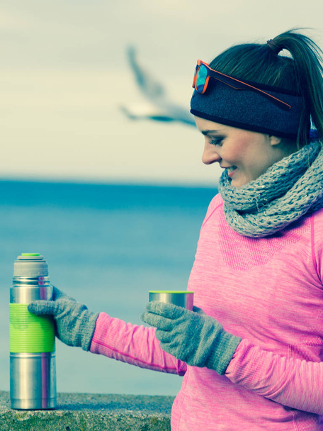 Fit woman in cold day warming up drink tea - Photo, Image
