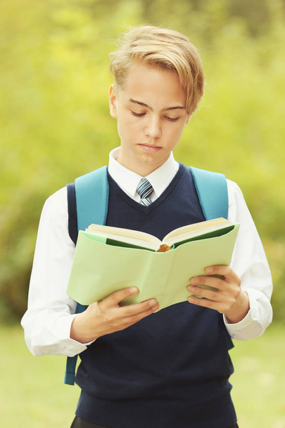 Handsome teenager with book in park - Valokuva, kuva