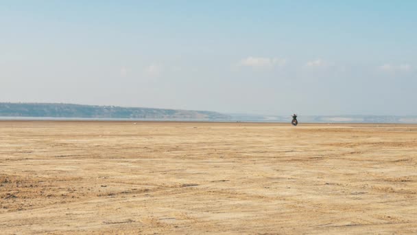 A motoros lovaglás, homokos strand mentén. Motoros túrák motorkerékpár a sivatagon keresztül. - Felvétel, videó