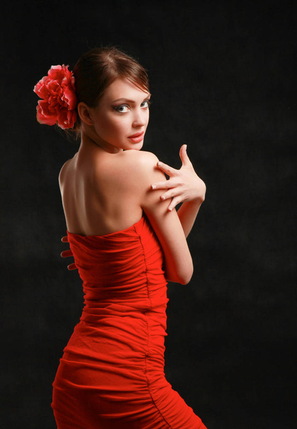 Young woman in red dress, isolated on black background - Fotó, kép